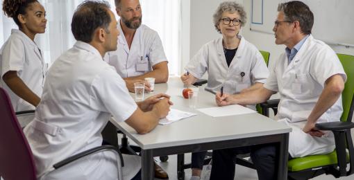 Artsen verzamelen rond een tafel voor een overleg
